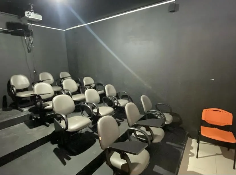 Sala com fileiras de poltronas cinza